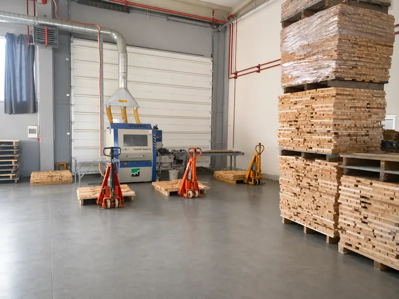 Moulder beside neatly stacked beech elements in the production hall