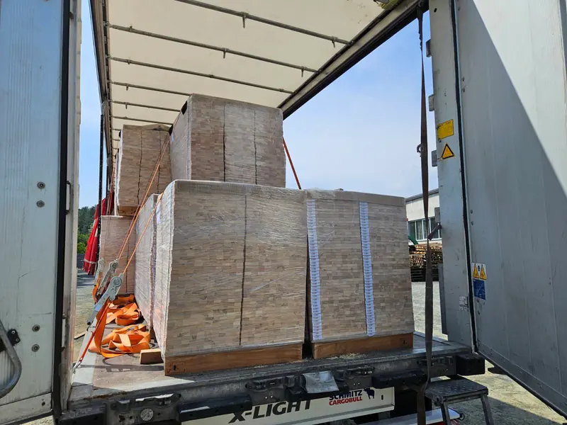 Verkistete Bettlatten-Elementpaletten auf einem Planenauflieger verladen