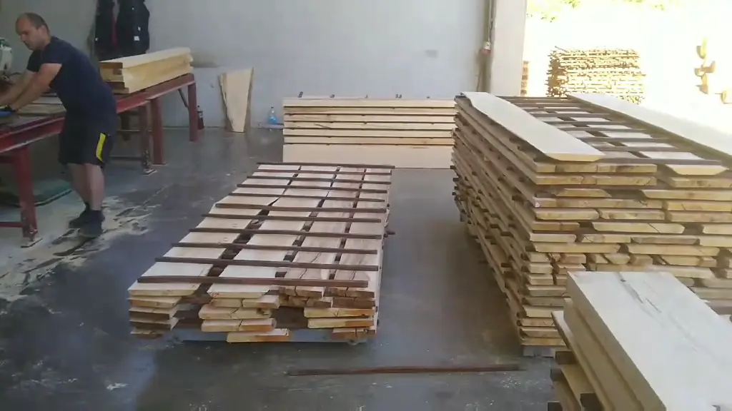 Radnik pored paleta složenih blanjanih bukovih elemenata u proizvodnoj hali